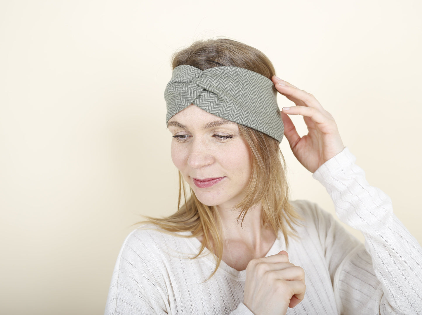 Frau streicht sich über ihr Stirnband