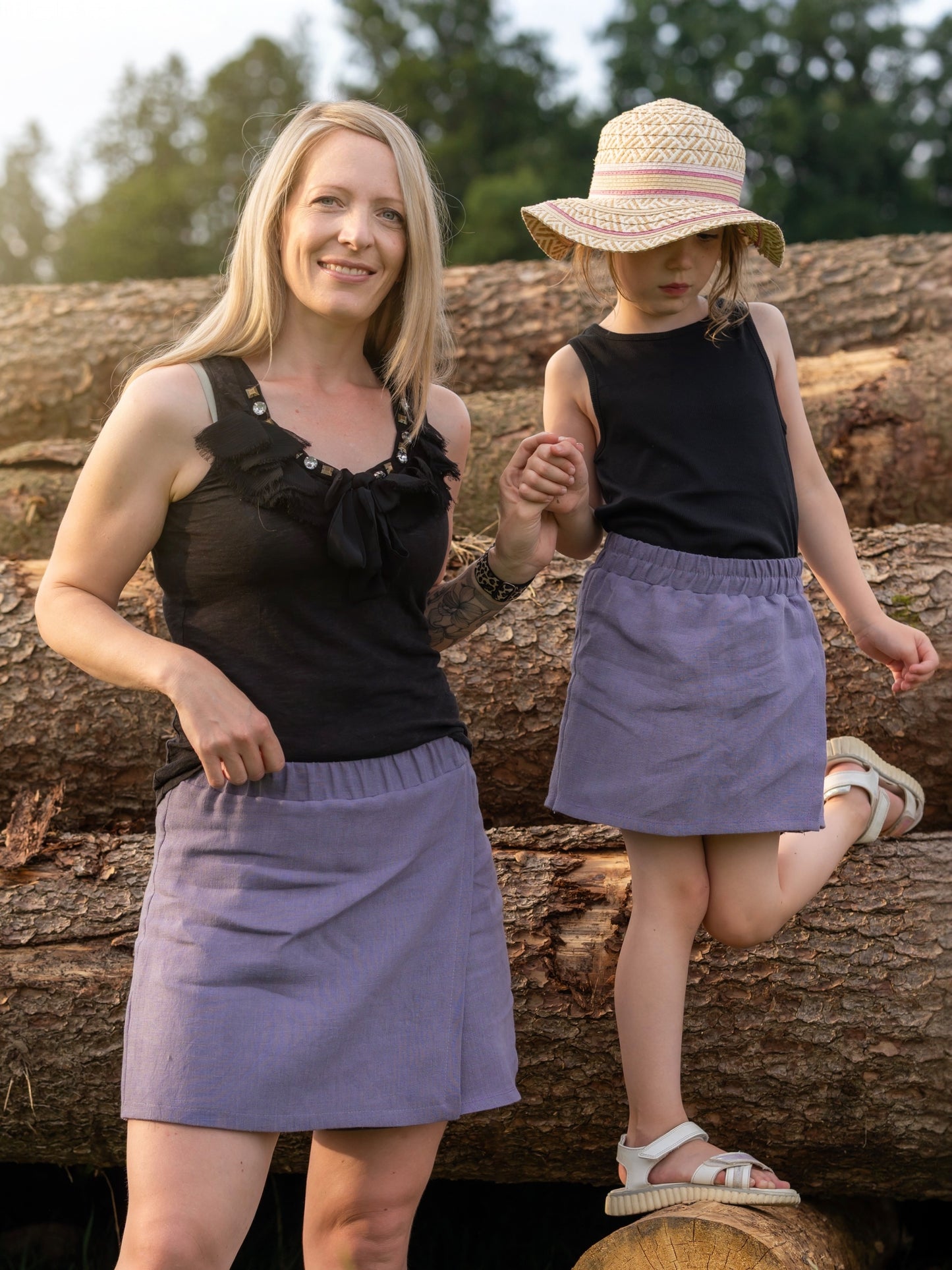 Blonde Frau hat ihre Tochter a der Hand - beide sind im Mini und Me Look