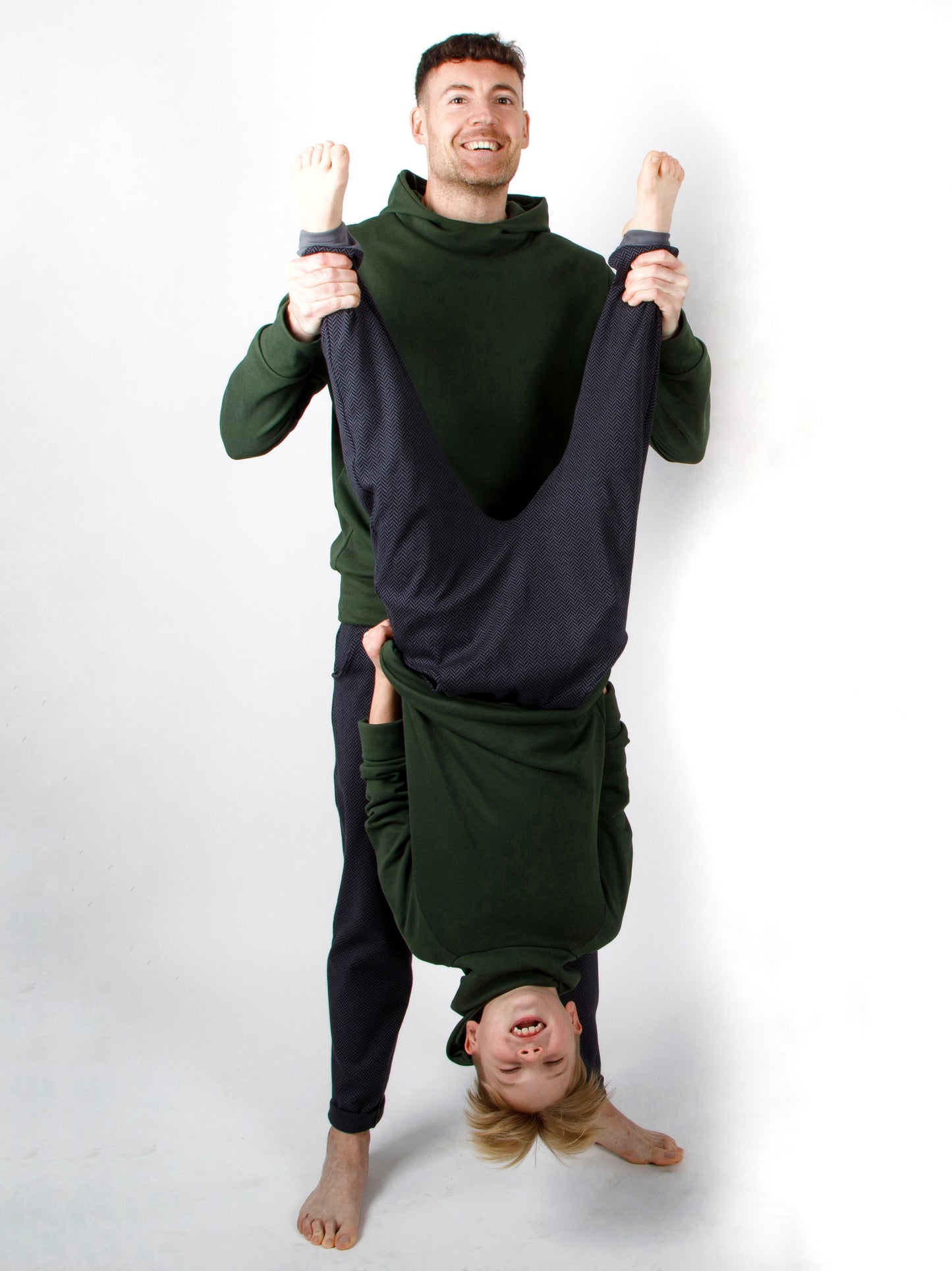 Vater und Junge sind im gleichen Look gekleidet mit einem Pullover und einer Hose aus Handarbeit