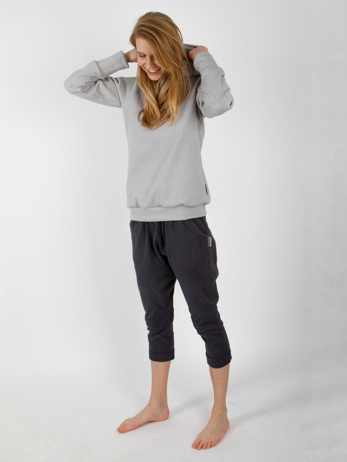 Frau trägt handgemachtes Outfit aus Naturfasern im zeitlosen und neutralen Design in schlichten Farben, sie trägt einen Hoodie für Damen und eine Pumphose
