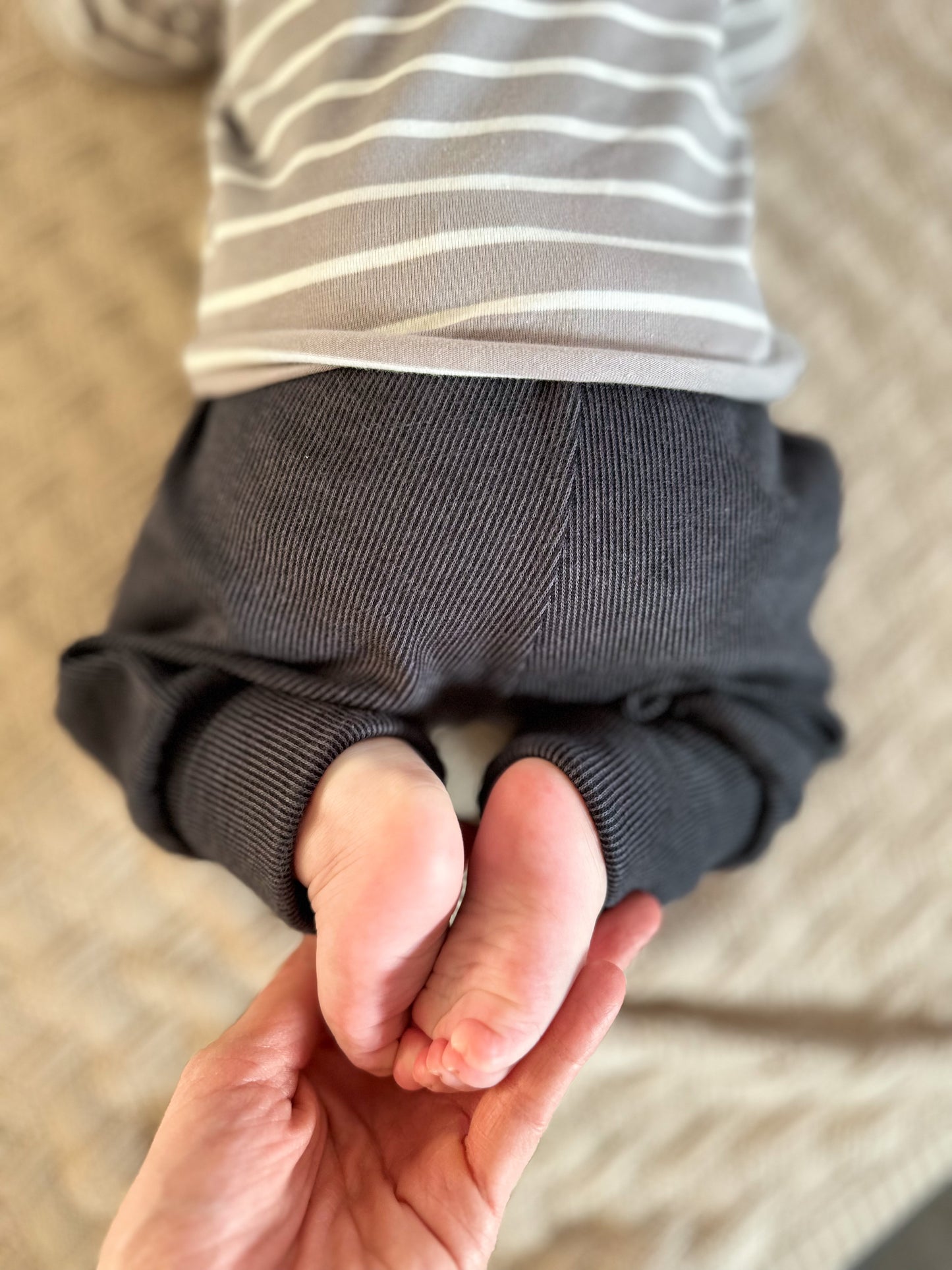 Mutter hält die Füßchen ihres Babys in ihren Händen