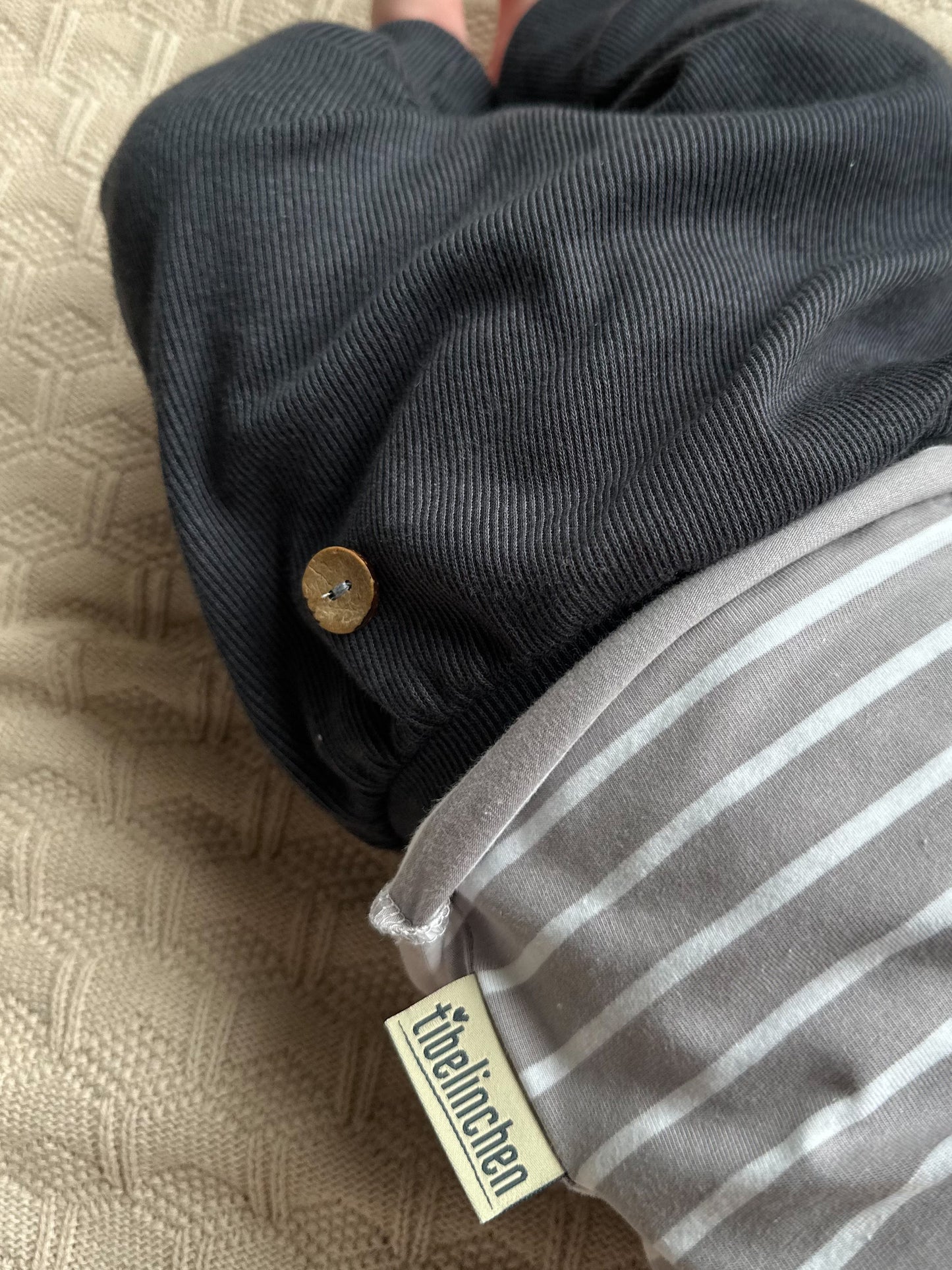 Details wie Holzknöpfe und Tibelinchenlabel an einem Outfit