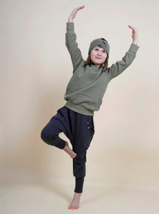Kind macht eine Yogapose und trägt bequeme Sachenn