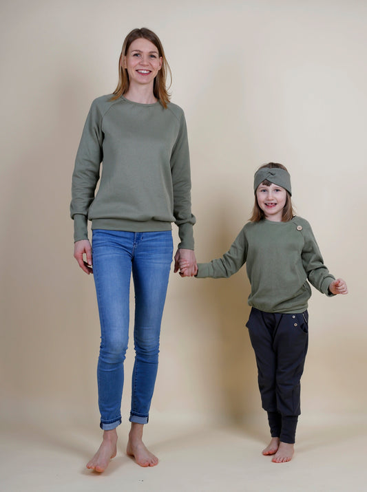 Mutter und Tochter tragen den gleichen Strickpullover