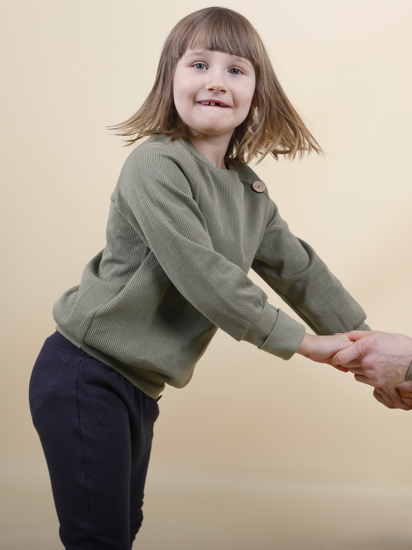 Mädchen trägt einen Pullover aus Biobaumwollstrick