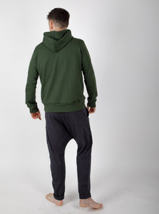 junger Mann mit grünen Hoodie und Jogginghose in schwarz aus fair produzierter ökologischer Baumwolle