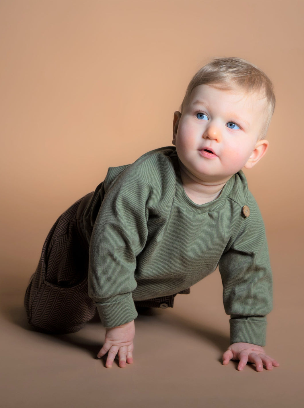 Baby trägt Outfit aus Naturfasern mit hohem Tragekomfort in neutralen Farben