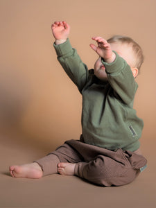 Kleinkind trägt Outfit in neutralen Farben aus Biobaumwolle
