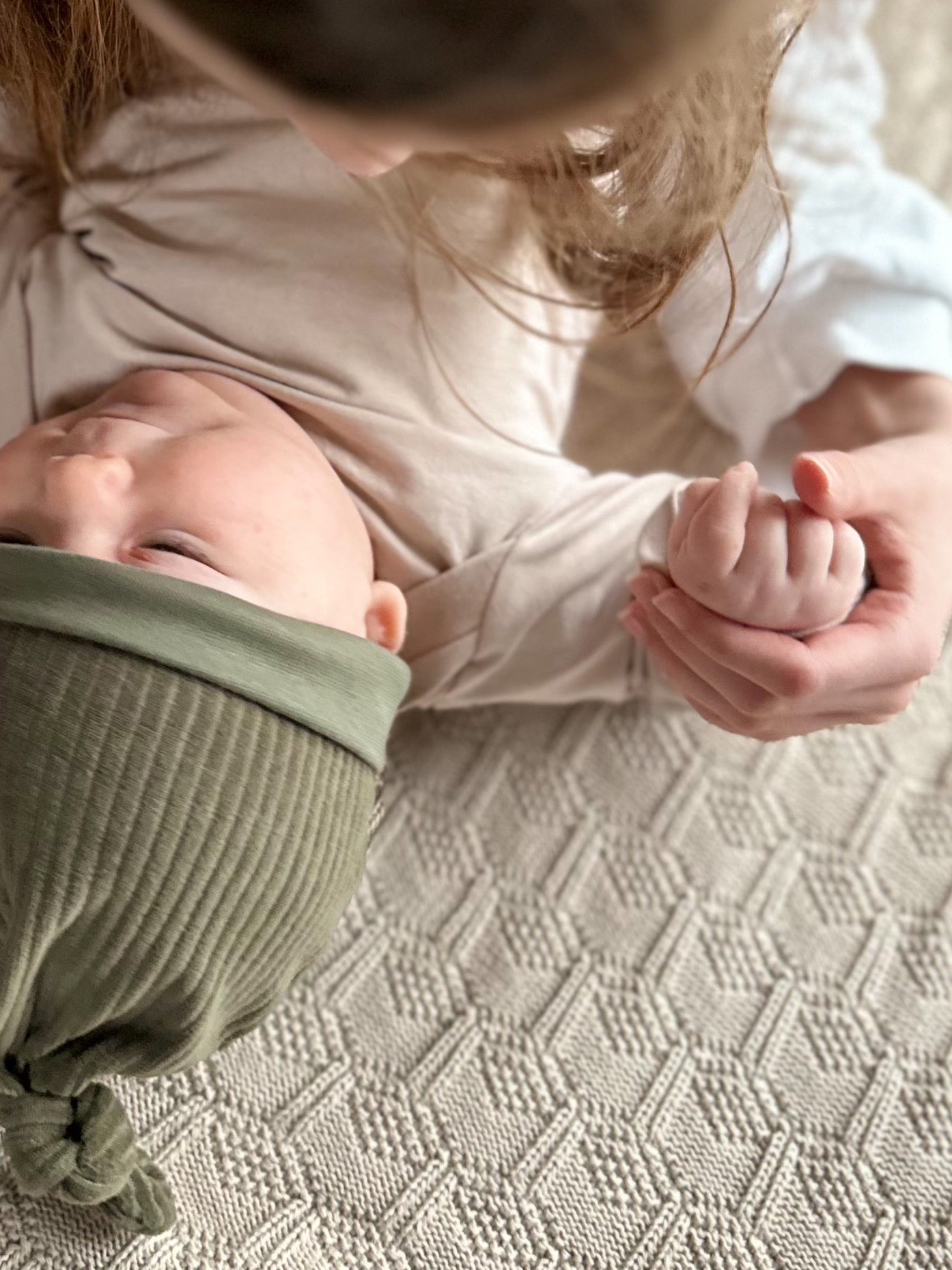 Große Schwester hält die Hand eines Babys