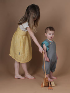 Mädchen in gelben Kleid spielt mit einem kleinen Jungen