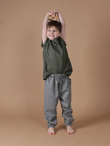 Ein Junge trägt grünes Hemd aus Leinen zu einer grauen Leinenhose