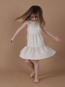 Mädchen dreht sich in einem schönen weißen Leinenkleid