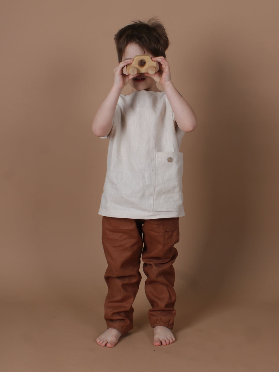 Kind trägt handgemachtes Leinenoutfit