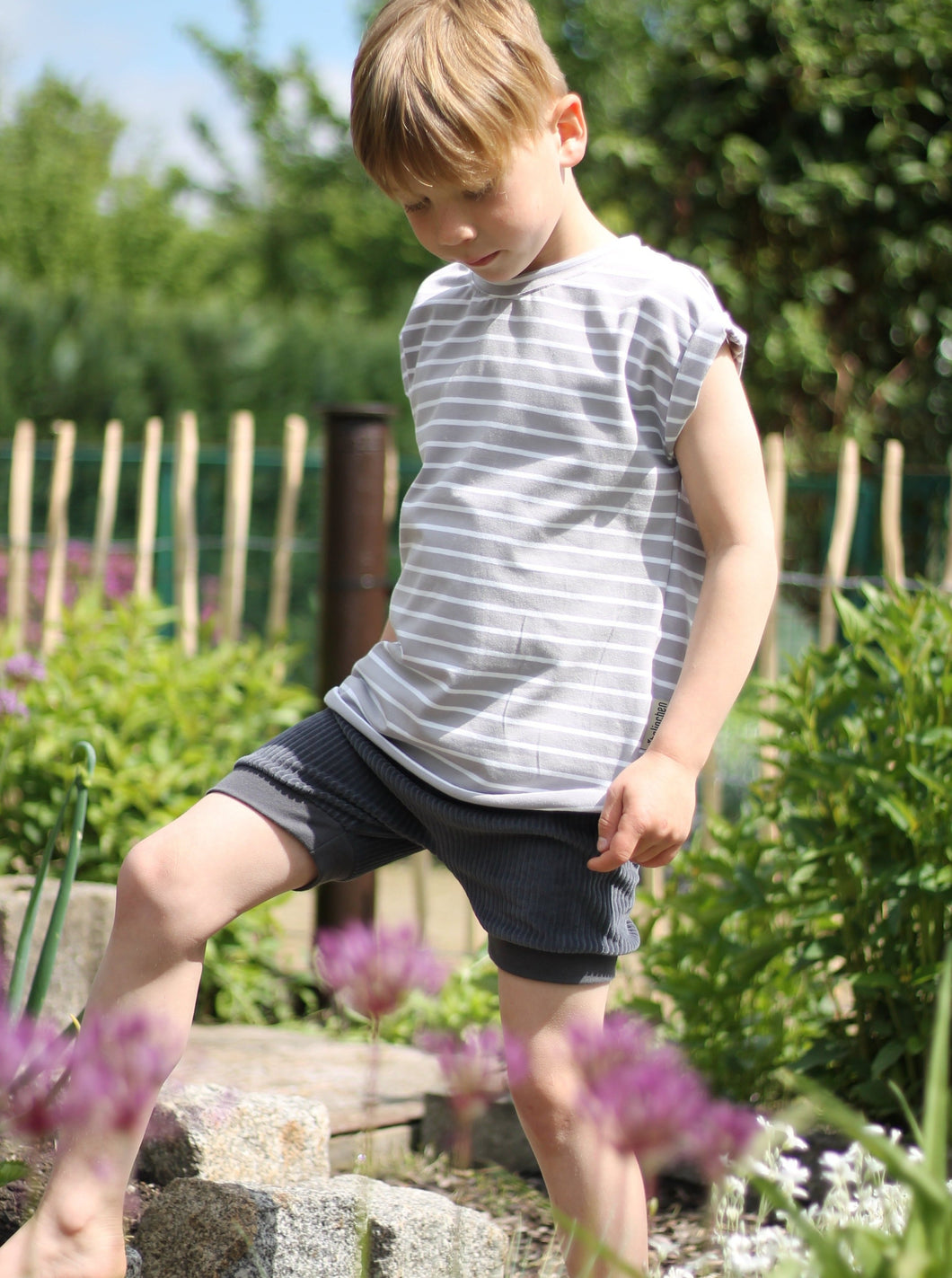 Junge trägt kurze Hose aus Biostoff mit gestreiften TShirt