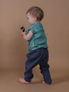 Kleinkind trägt petrolfarbenes Leinenshirt und eine blaue Leinenhose