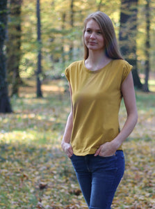 Frau läuft durch den Wald und trägt ein Jerseyshirt aus Naturfasern